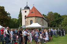 Účastníci bohoslužby na louce na Levém Hradci